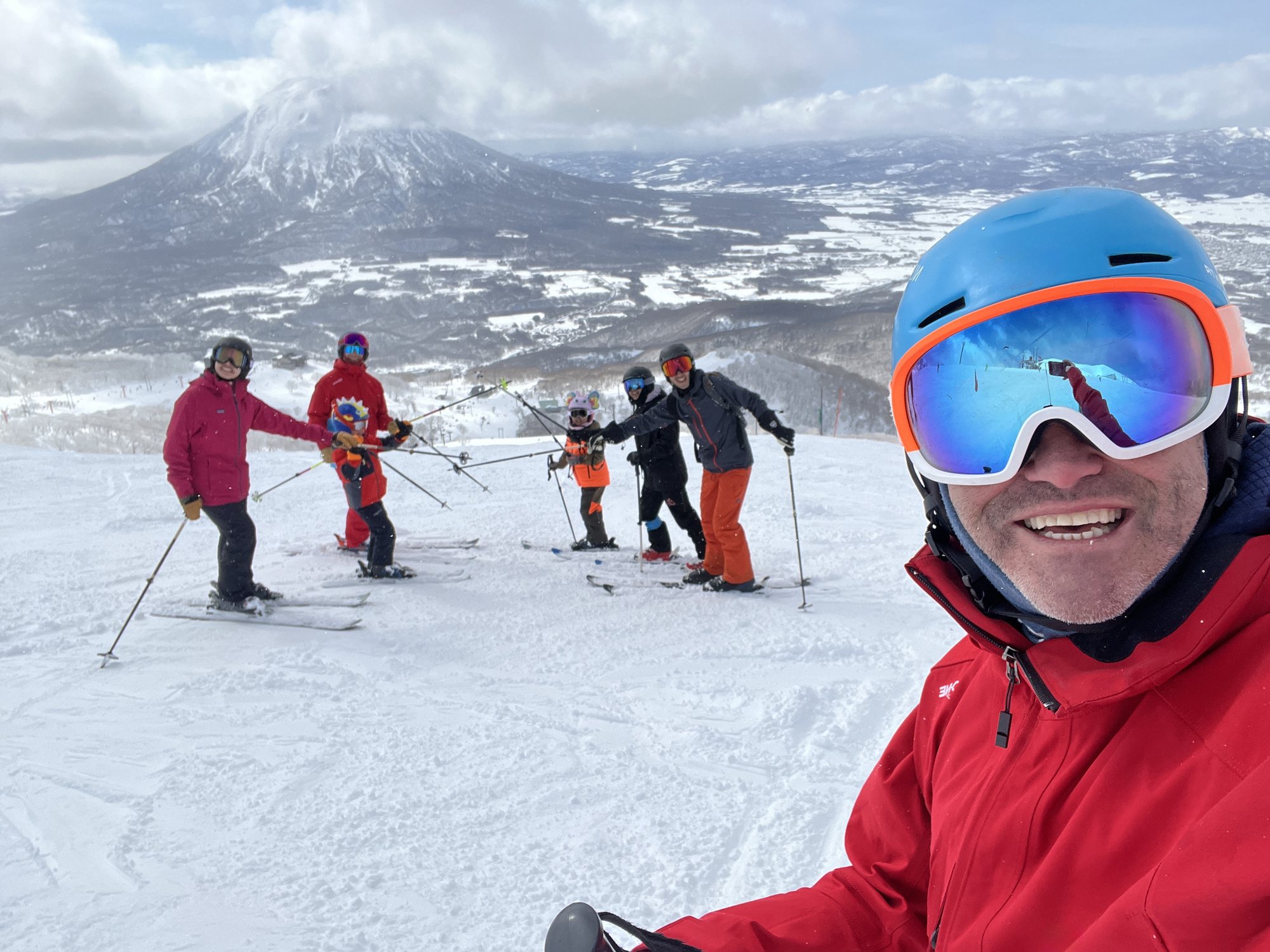 Ash Johns skiing with guests in Niseko with Mount Yotei behind them