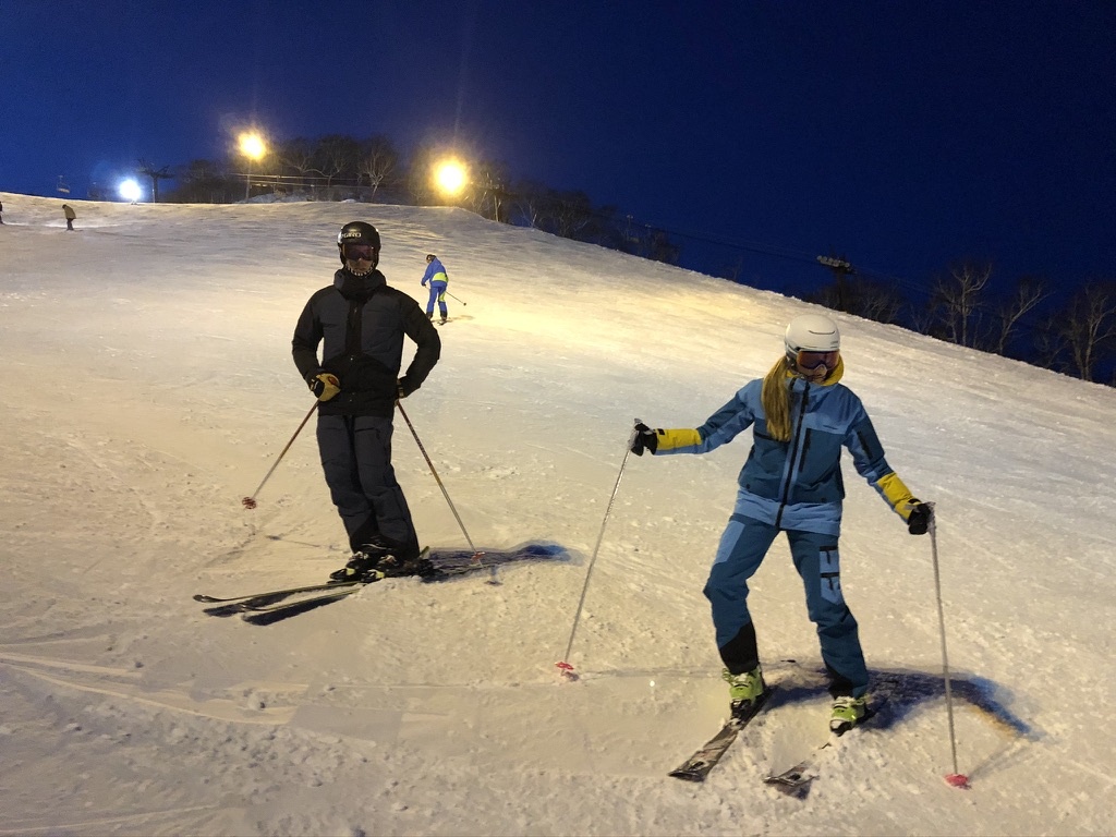 Two skiers enjoying a private twilight lesson under the lights in Niseko